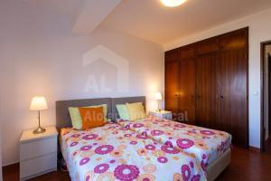 エリセイラにあるCasa do Sol by AcasaDasCasasのベッドルーム1室(花の咲く大型ベッド1台付)