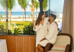 een man en een vrouw op een stoel voor een raam bij Hotel Praia do Sol in Ilhéus