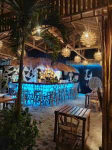 un restaurante con un bar con mesas y sillas en Zhaya's Beach & Cottages, en El Nido