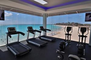 um ginásio com vista para a praia e máquinas de cardio em Divi One Bedroom em Palm-Eagle Beach
