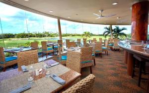 a restaurant with tables and chairs and a large window at Divi One Bedroom in Palm-Eagle Beach