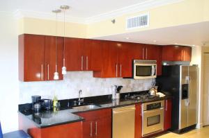 a kitchen with wooden cabinets and a stainless steel refrigerator at Divi One Bedroom in Palm-Eagle Beach
