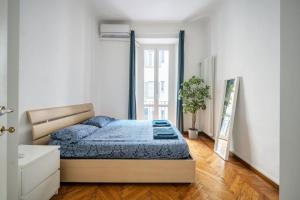 Un dormitorio con una cama y una planta. en Nice apartment in Milan Porta Venezia Duomo, en Milán