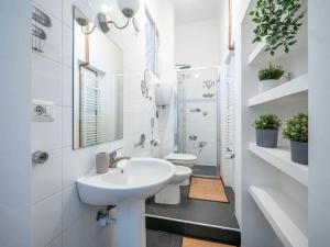 Un baño blanco con lavabo e inodoro. en Nice apartment in Milan Porta Venezia Duomo, en Milán