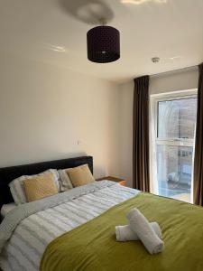 - une chambre avec un grand lit et une fenêtre dans l'établissement Entire Kingston Two bedroom Apartment Town centre & River view, 32 minutes to London Waterloo Station, à Londres