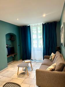 ブレイユ・シュル・ロワイヤにあるappartement Breil sur Roya centreのリビングルーム(青いカーテン、ソファ付)