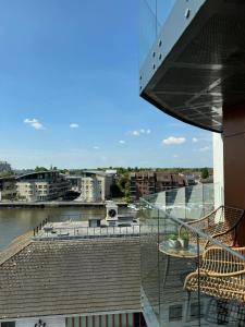 a balcony with a view of a river and buildings at Entire Kingston Two bedroom Apartment Town centre & River view, 32 minutes to London Waterloo Station in London