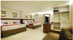 a hotel room with two beds and a television at Lirio D'Água Hotel in Olímpia +35 photos