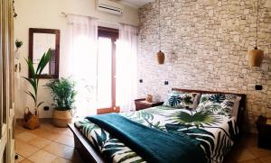um quarto com uma cama e uma parede de pedra em Mialma Rome Holiday Home Casa lontano da casa em Ciampino