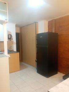 eine Küche mit einem schwarzen Kühlschrank im Zimmer in der Unterkunft Departamento Temporario Rio Grande in Río Grande