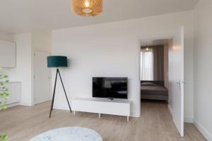 uma sala de estar com televisão numa parede branca em K50161 Modern apartment near the center and free parking em Eindhoven