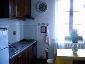 a kitchen with a sink and a table with a vase at Agriturismo La Burra di Vinci Appartamento "Casina" in Vinci