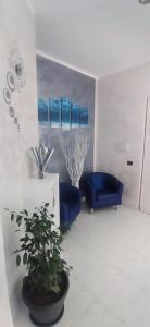 a room with two blue chairs and a potted plant at B&B La Munachell in Vieste