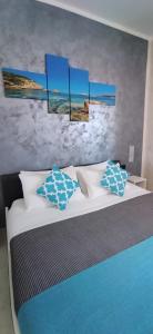 B&B La Munachell في فييستي: غرفة نوم مع سرير ووسائد زرقاء وبيضاء