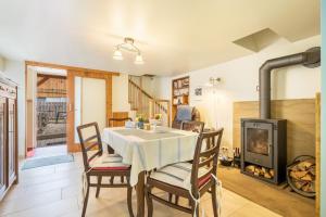 a dining room with a table and a fireplace at Chalet Kunterbunt in Langenwetzendorf