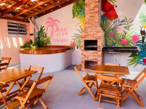 a patio with tables and chairs and a fireplace at Pousada Pura Vida Bertioga in Bertioga +23 photos