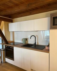 a kitchen with white cabinets and a sink at Le logis de Bodard in Chinon