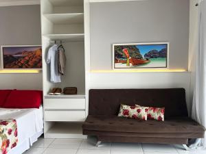 1 dormitorio con 1 cama y un banco en una habitación en Mar Y Suites, en Cabo Frío