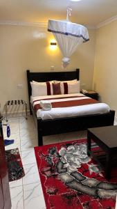 a bedroom with a large bed with a red rug at White Star Hotel in Nairobi