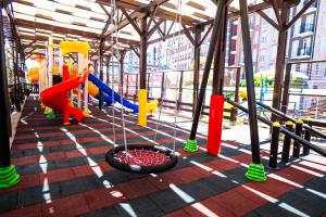 a play area with a playground with a swing at Orange County Kemer Family Only in Kemer