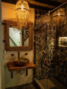uma casa de banho com um lavatório e um chuveiro com um espelho. em Jungla EcoLuxury Resort em Villeta