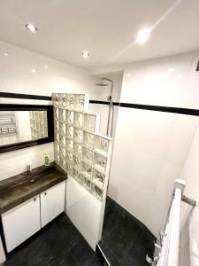 a bathroom with white walls and a sink and a shower at appartement Breil sur Roya centre in Breil-sur-Roya +25 photos