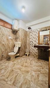 La salle de bains est pourvue de toilettes, d'un lavabo et d'un miroir. dans l'établissement Ganga Cottage !! 1,2,3 bedrooms cottage available near mall road manali, à Manali