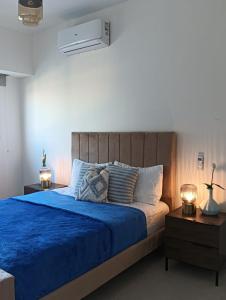Rental house Santo Domingo في سانتو دومينغو: غرفة نوم بسرير ازرق مع مواقف ليلتين