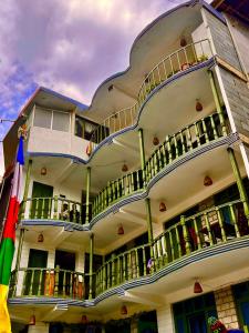 a large white building with balconies and a flag at Ganga Cottage !! 1,2,3 bedrooms cottage available near mall road manali in Manāli