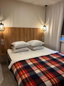 een slaapkamer met een groot bed en een geruite deken bij Best Holiday Port Grimaud in Grimaud