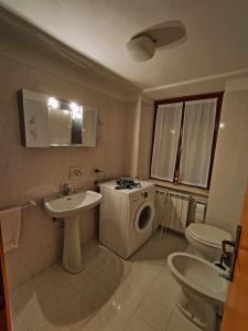 a bathroom with a sink and a washing machine at Appartamento centro storico in Ornica