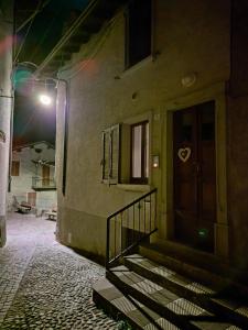 a building with stairs and a door with a light at Appartamento centro storico in Ornica