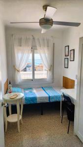 een bed in een kamer met een raam en een tafel bij Canet playa y centro in Canet de Mar