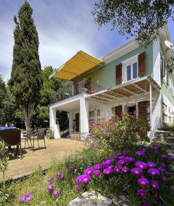 ein Haus mit lila Blumen davor in der Unterkunft La casa tra gli alberi e il cottage in Fiskardo