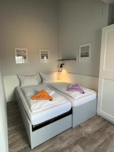 a bed with an orange towel on it in a room at Appartementhaus Westerloog 20 in Spiekeroog
