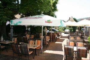 an outdoor restaurant with tables and chairs under an umbrella at Restaurant Orakel in Oberstenfeld