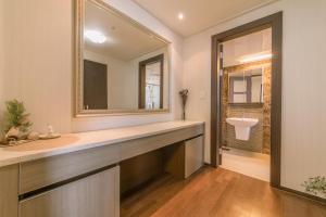 uma casa de banho com um espelho grande e um lavatório em Big Party Room House em Busan
