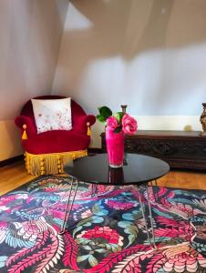 a living room with a red chair and a table at Le logis de Bodard in Chinon