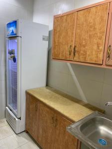 a kitchen with a sink and a refrigerator at The Traveler Hostel in Riyadh