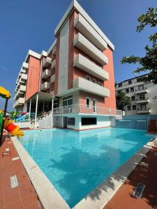 een gebouw met een zwembad voor een gebouw bij Hotel Delfino in Milano Marittima
