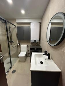 a bathroom with a sink and a toilet and a mirror at la casa de Adela - Cala lanuza in El Campello
