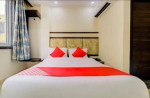 a bedroom with a large white bed with red pillows at Hotel India continental in New Delhi