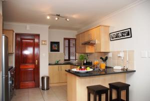 a kitchen with wooden cabinets and a counter top at 13 Bella Rosa Apartment in Durbanville