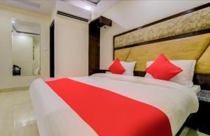a bedroom with a large bed with red pillows at Hotel India continental in New Delhi