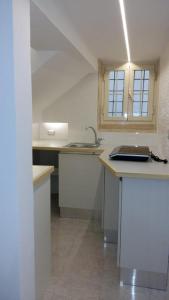a white kitchen with a sink and a counter top at Casa Per 2 in Porto Santo Stefano