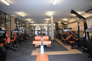 einen Fitnessraum mit vielen Trainingsgeräten und orangefarbenen Stühlen in der Unterkunft 13 Bella Rosa Apartment in Durbanville