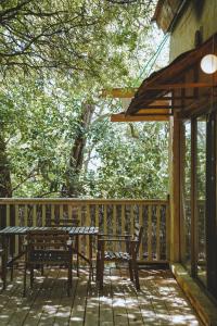 - une terrasse en bois avec une table et des bancs dans l'établissement THE HOUSE IN THE OAKS הבית באלונים, à Amirim