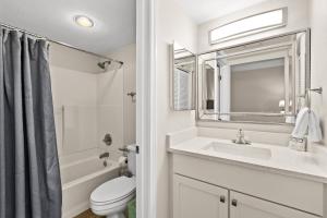ein Badezimmer mit Waschbecken, Toilette und Spiegel in der Unterkunft SunDestin Resort Unit 0112 in Destin