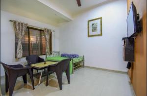 a living room with a couch and a table and chairs at LAUGHTALE VILLA 4Bhk Swimming Pool in Lonavala