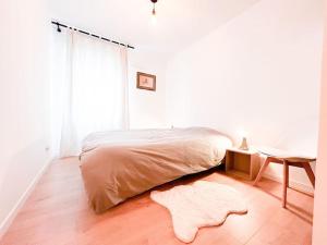 1 dormitorio con cama, mesa y alfombra en Le Nid de la Liberté, en Nantes